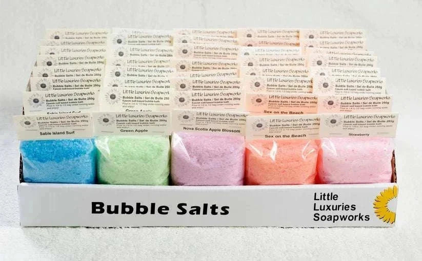 Assorted colorful bubble bath salts in resealable pouches by Little Luxuries Soapworks for relaxing and hydrating skin.