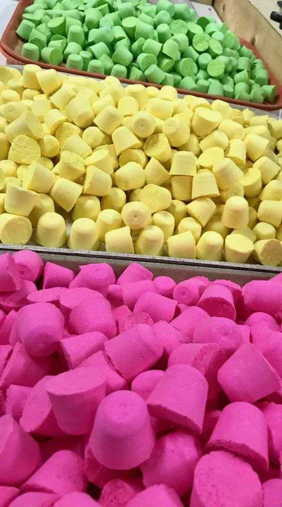 Colorful foaming bath bombs in green, yellow, and pink for relaxing and fun baths.