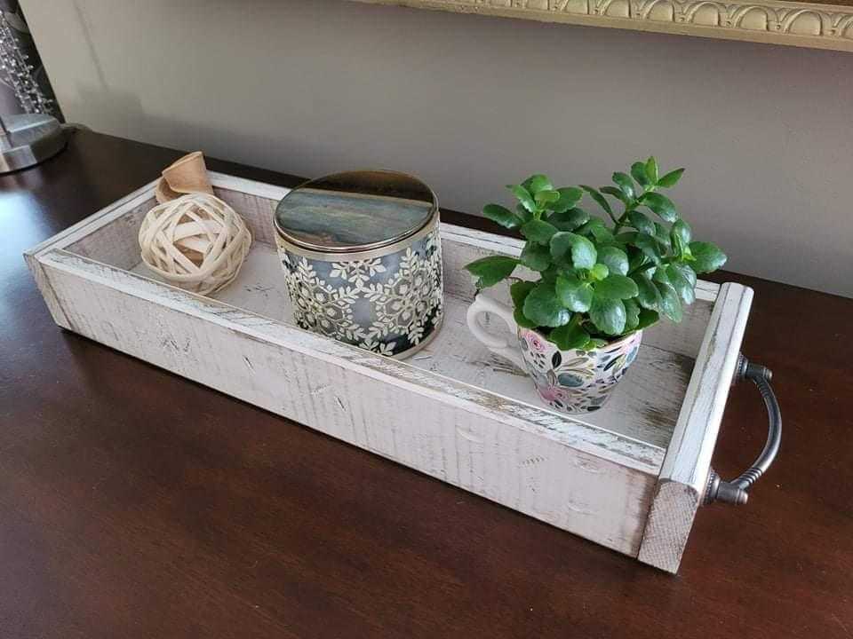 Antiqued wooden trays with handles displaying decorative items.