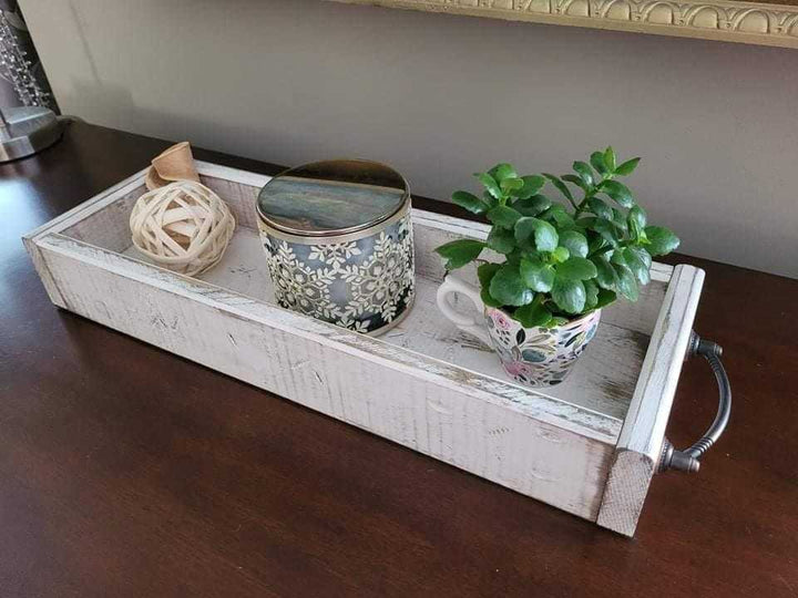 Antiqued wooden trays with handles displaying decorative items.