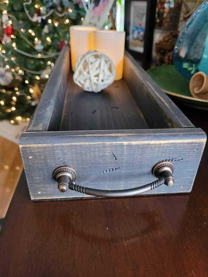 Antiqued wooden trays with handles, rectangular shape, displayed on table with decorative items.