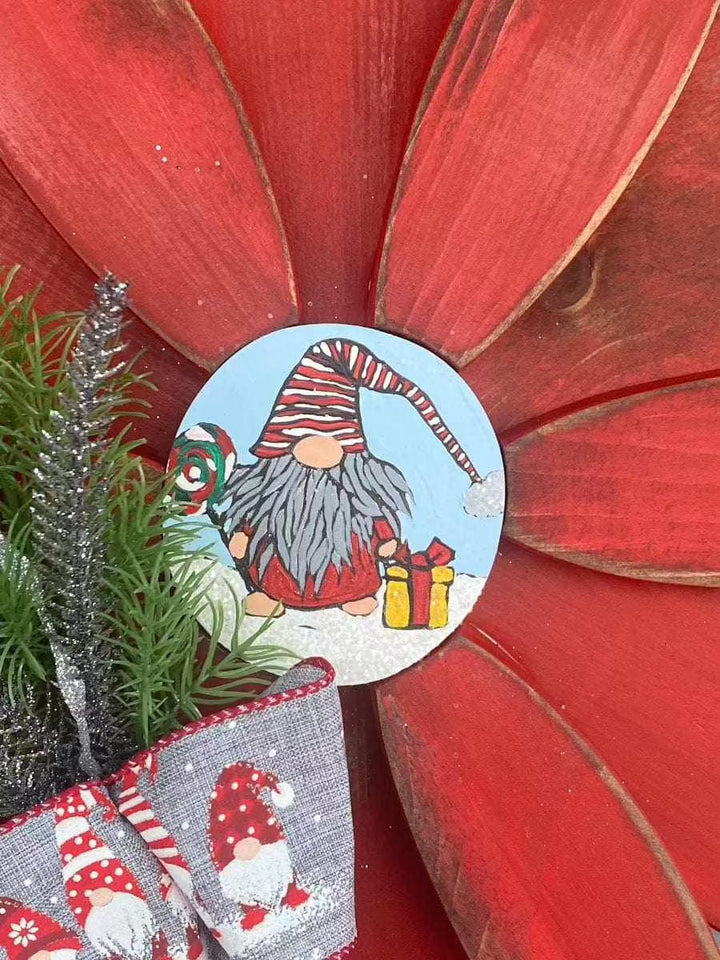 Hand-painted Christmas gnome on red flower décor with festive bow and greenery.