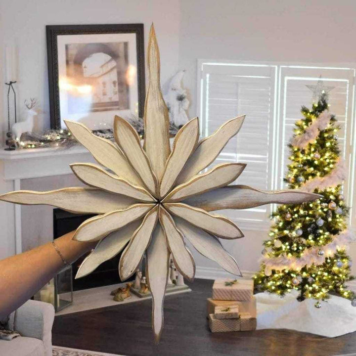 Handcrafted snowflake decoration with pine construction, displayed indoors, capturing Maritime winter beauty.