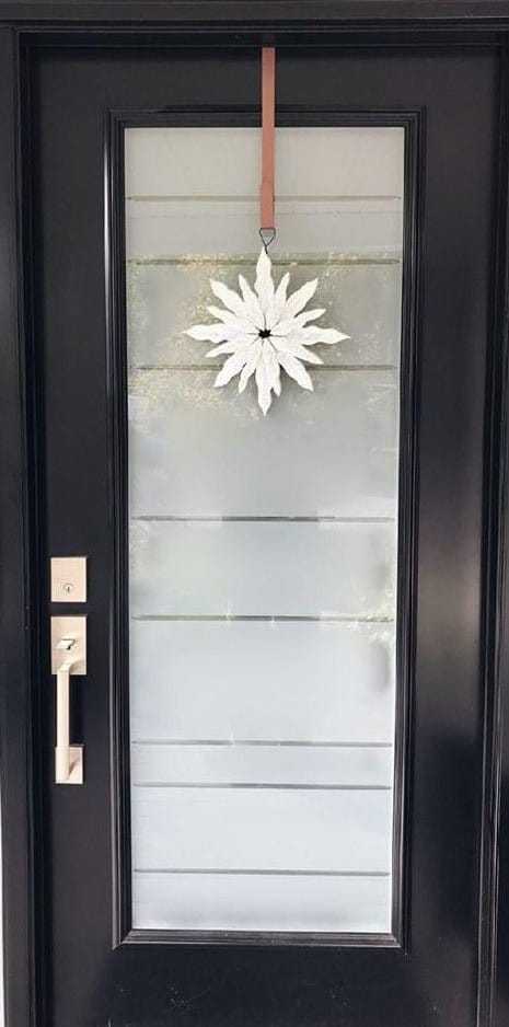 Handcrafted snowflake decoration on front door, reflecting Maritime winter beauty.