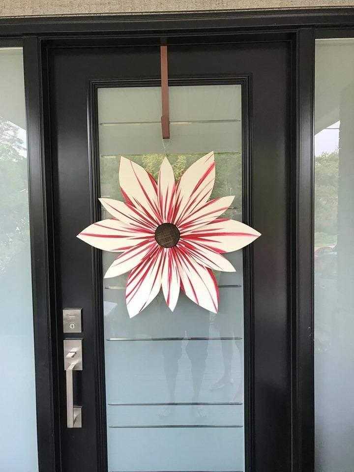 Candy Stripe Wood Flower Door Decoration in red and white candy cane colors on a glass-paneled door.