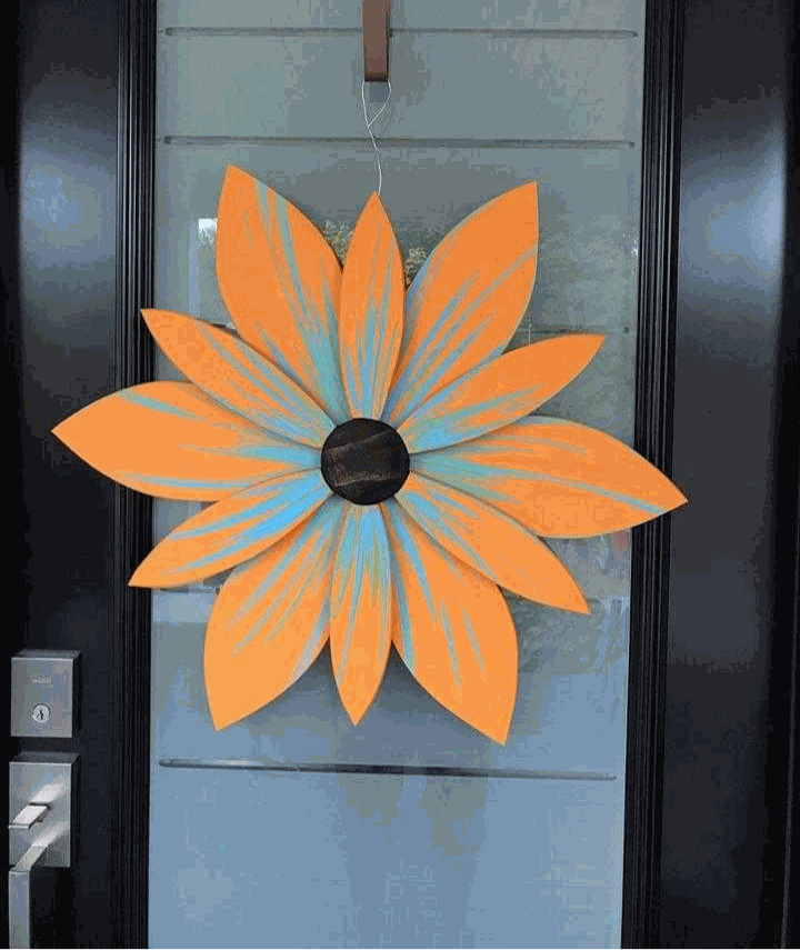 Handcrafted orange and blue wooden flower door art from Nova Scotia.