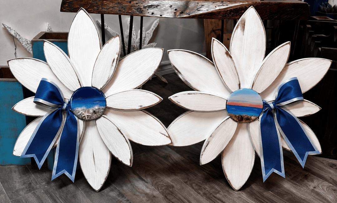 Two decorative flowers with blue hand poured resin centers on a wooden flowers