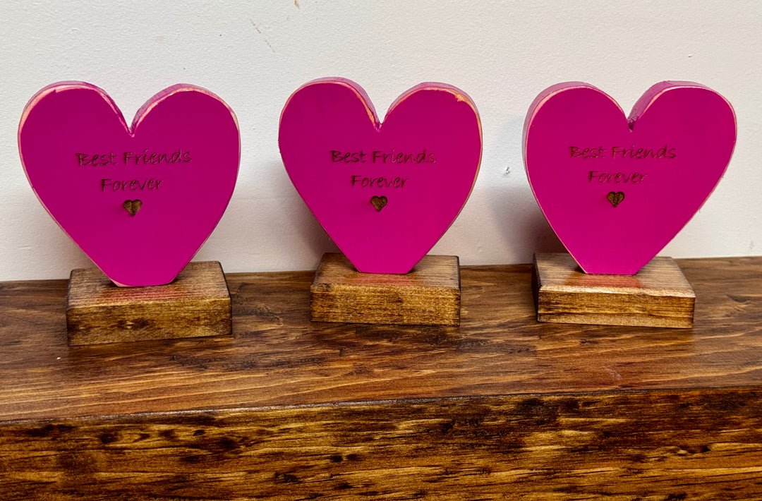 Three pink heart-shaped plaques with &