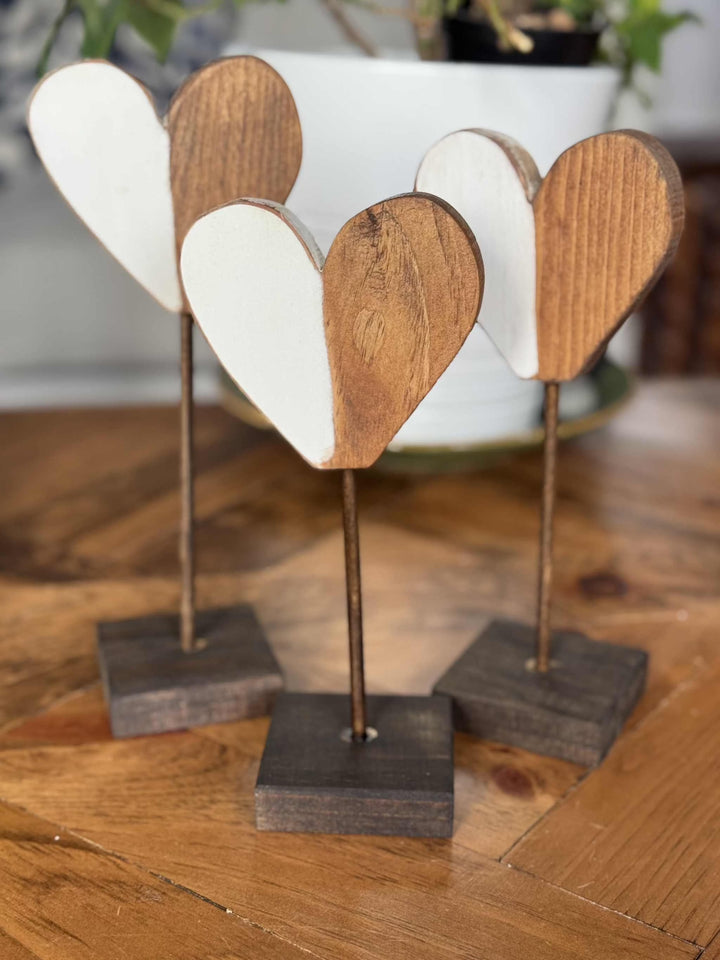 Handcrafted wooden hearts with rustic finish on stands, perfect for home decor or gifts.