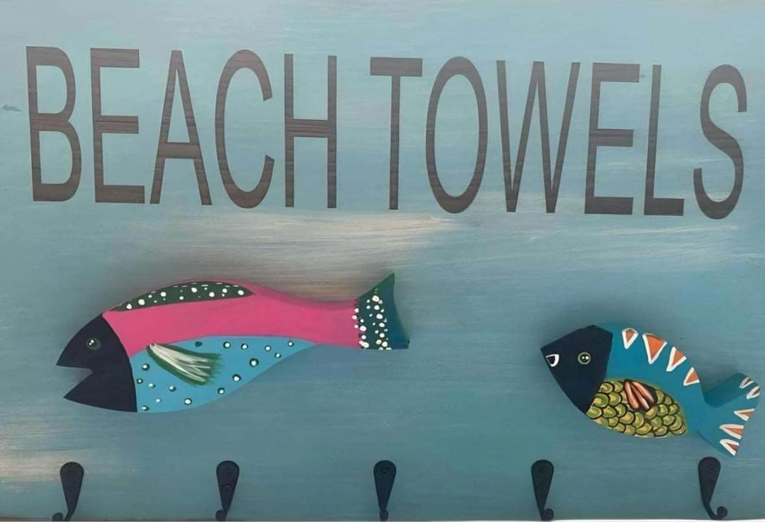 Hand-painted wooden fish beach towel holders with metal hooks.