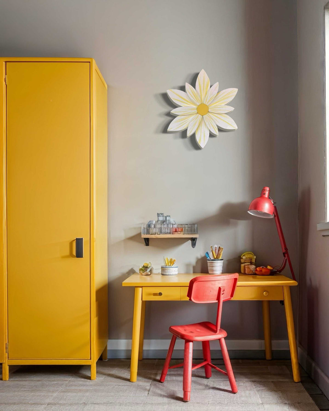 Sunburst flower wood art decorating a bright yellow room with desk and chair.