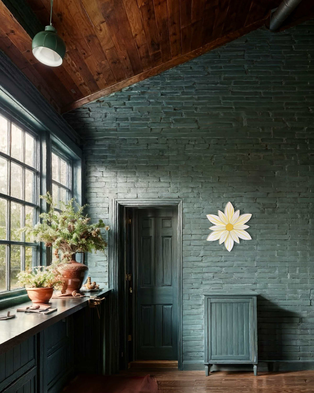 Handcrafted sunburst flower wood art decoration on a dark brick wall in a cozy room.