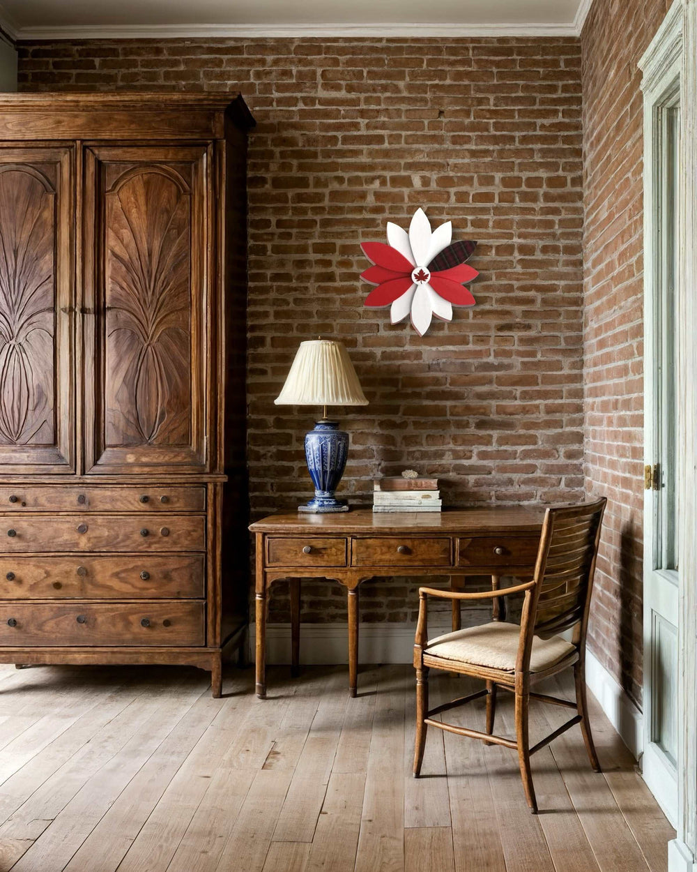 Handcrafted red and white wooden flower decoration on a brick wall indoors.