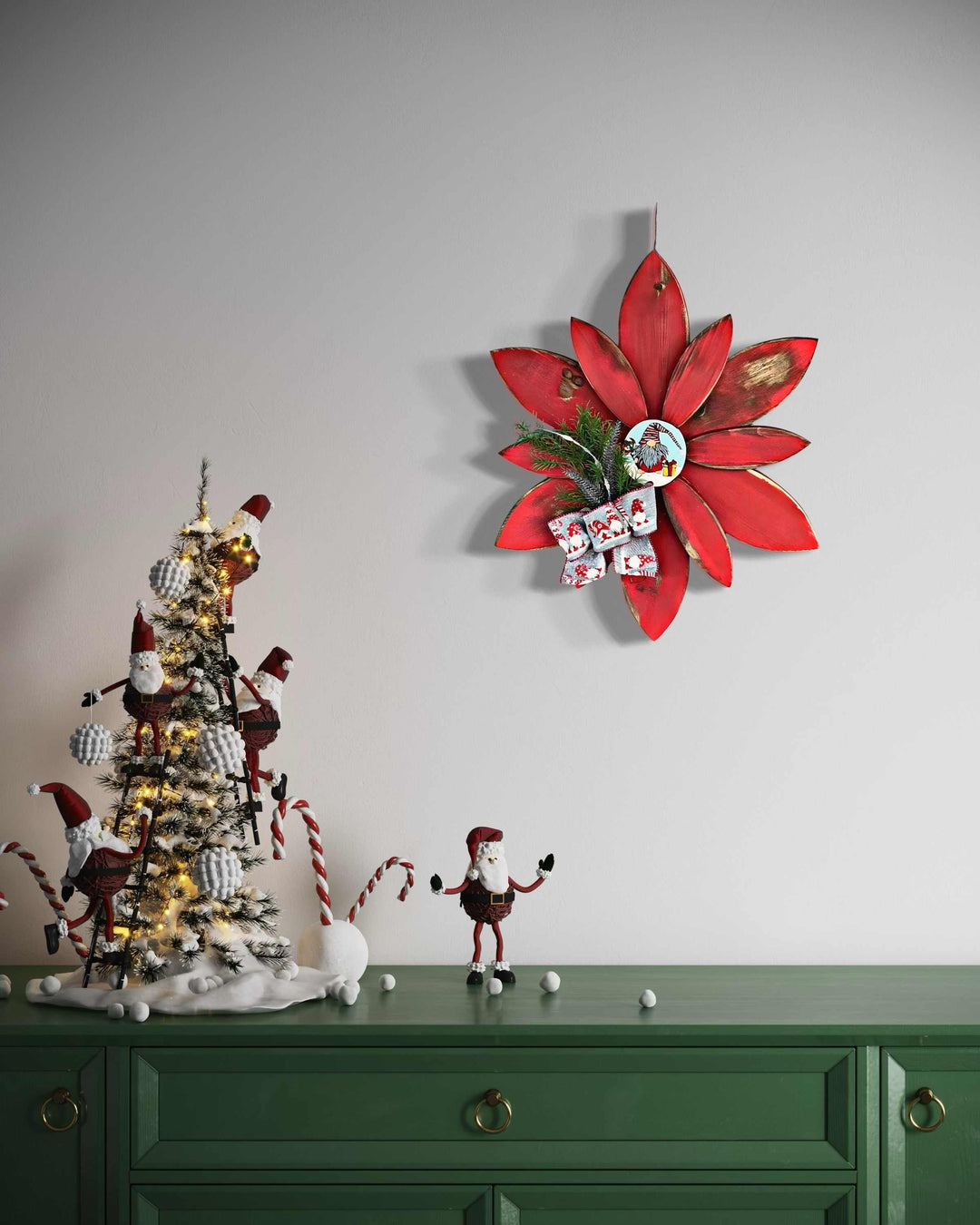 Hand-painted red Christmas flower gnome decoration with festive gnome figure, displayed on a green table next to a Christmas tree setup.