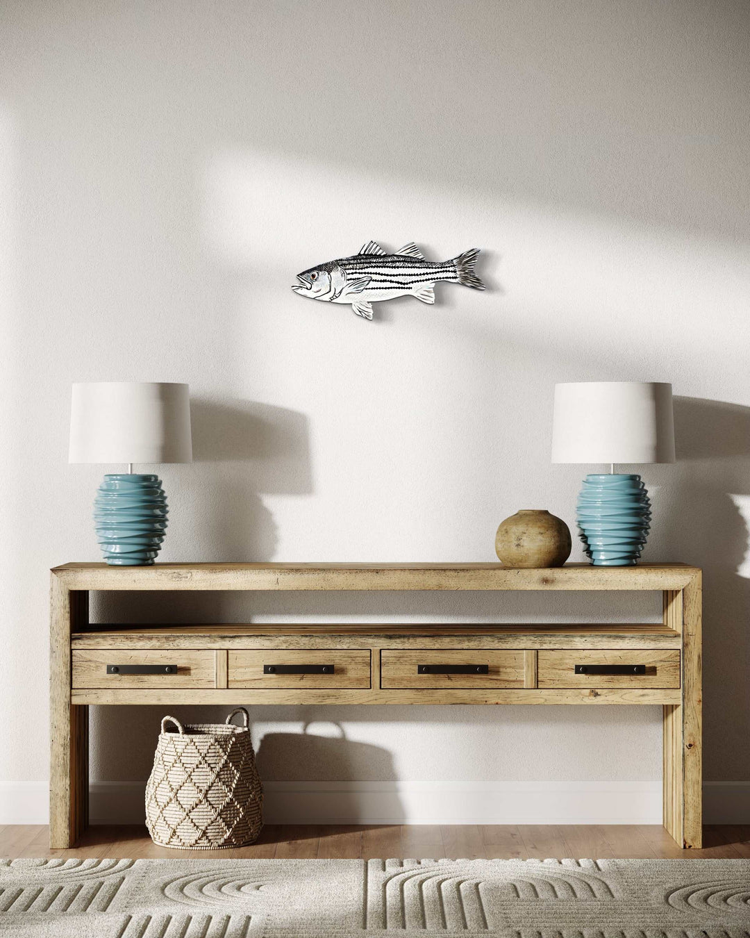 Hand-painted striped bass fish artwork displayed between decorative table lamps.