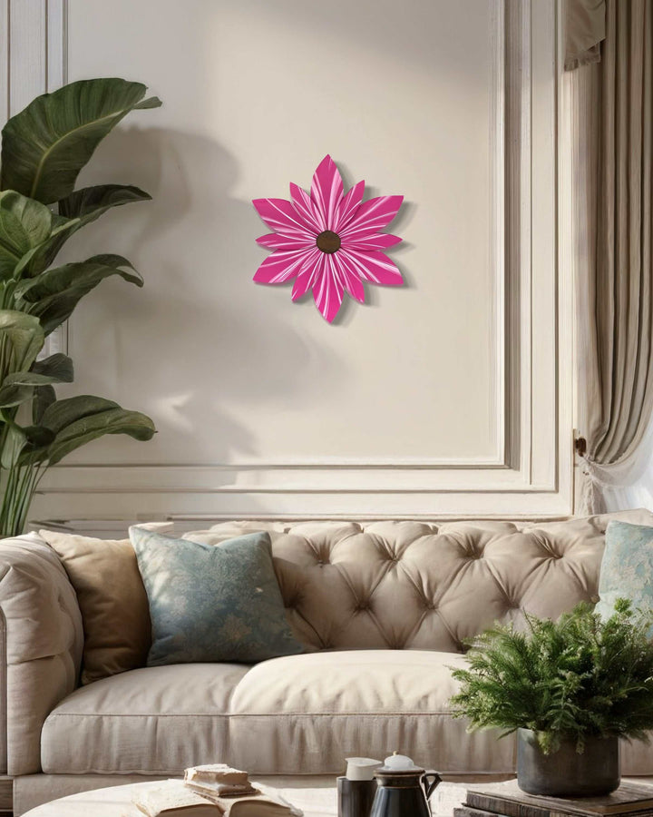 Hand-painted wooden flower door decor in vibrant pink displayed on wall above beige sofa.