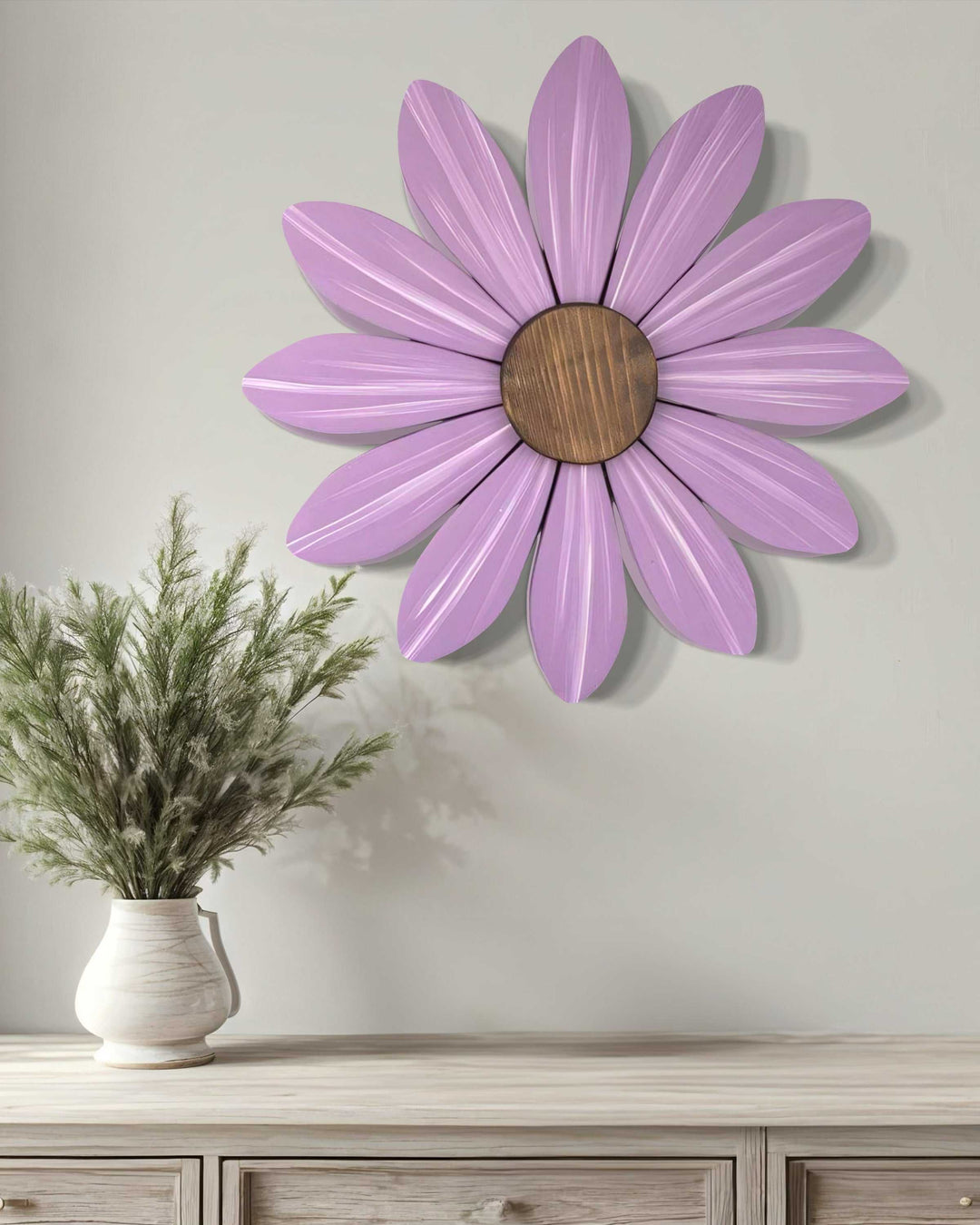 Purple handmade wooden daisy wall art with a wooden center against a light gray wall.