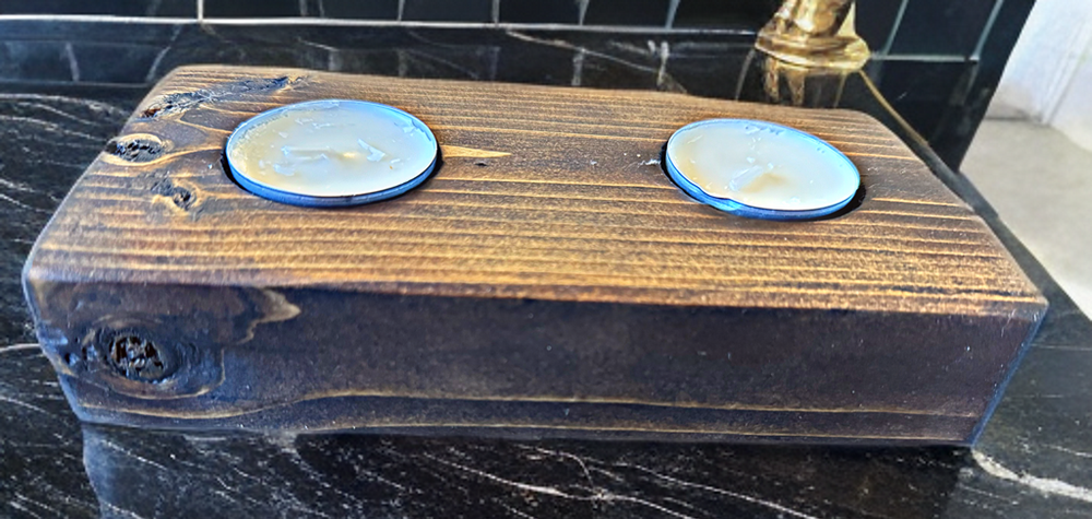 Handcrafted wooden tea light holder with a rustic finish holding two candles, perfect for unique home décor.