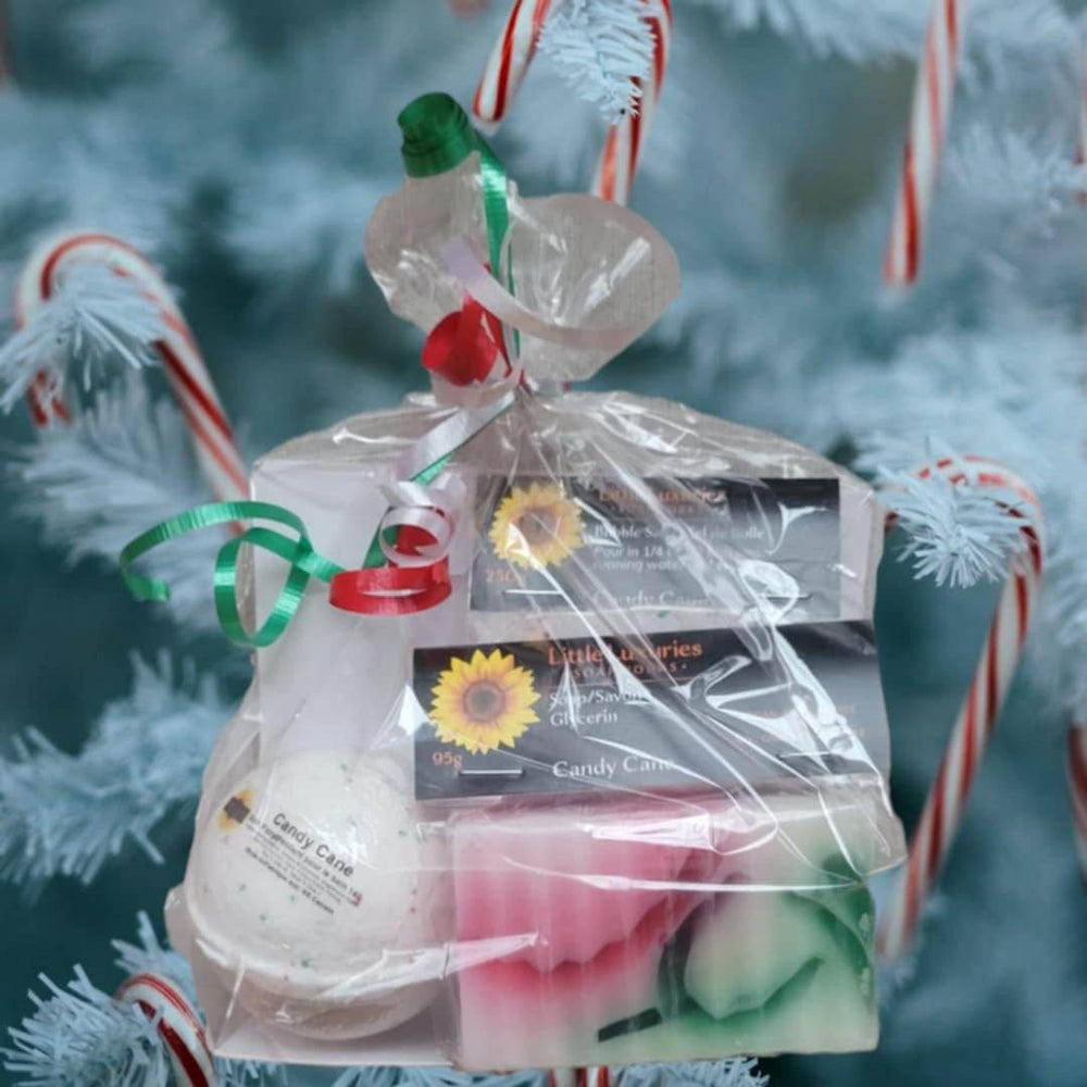 Gift set with soap, bath bomb, and bubble salts hanging on a festive tree with candy canes.