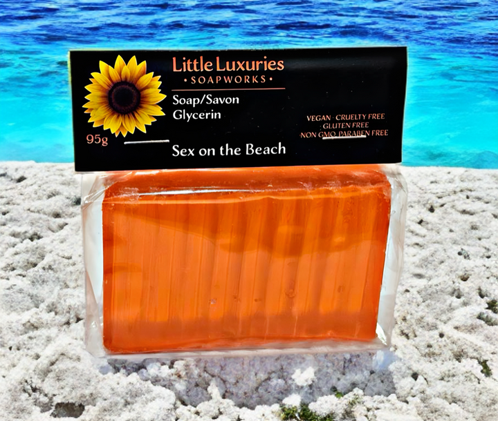 Glycerin soap bar "Sex on the Beach" by Little Luxuries Soapworks, vegan and paraben-free, on a beach background.