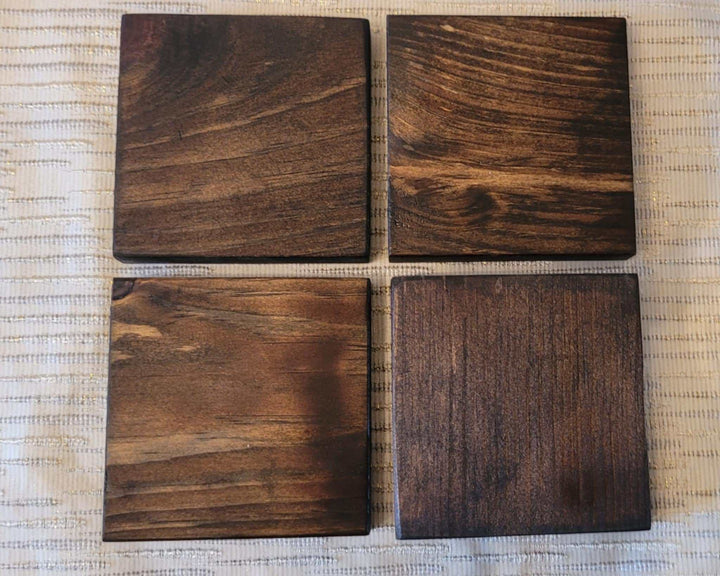 Set of 4 handcrafted rustic wood coasters on a textured surface.