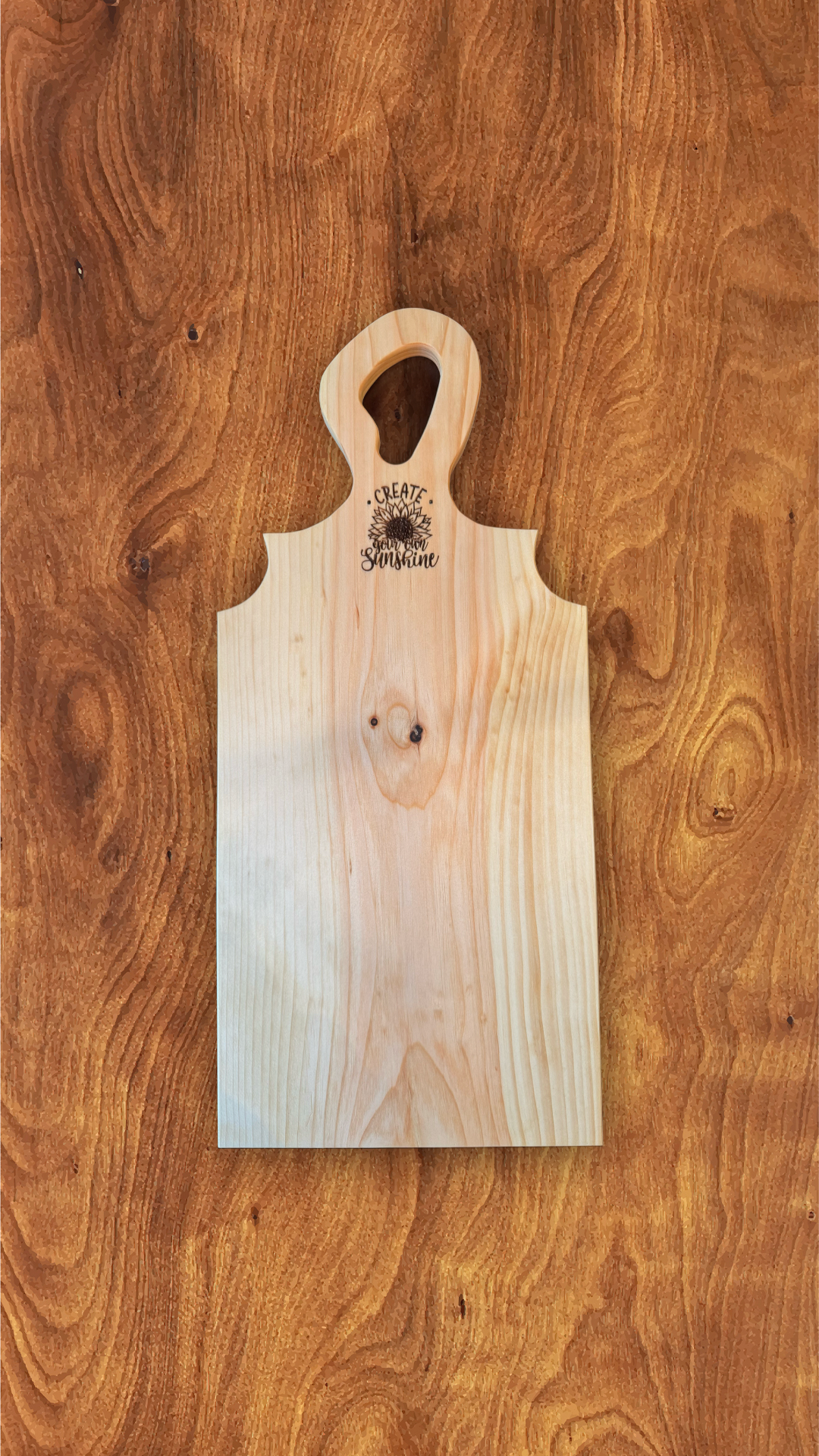 Handcrafted pine charcuterie board with laser engraving, 25" x 11", on wood surface.