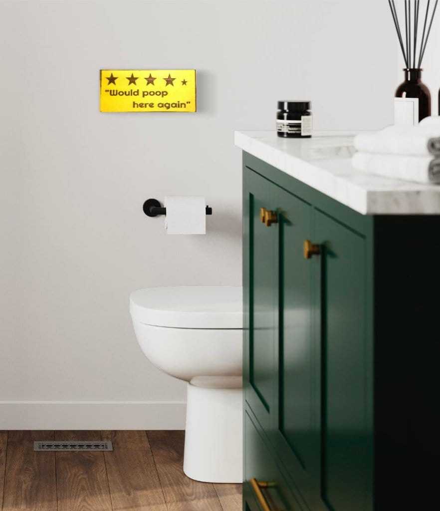 Rustic "Would Poop Here Again" bathroom sign in a modern bathroom.