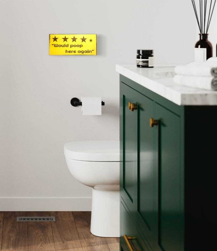 Rustic "Would Poop Here Again" bathroom sign in a modern bathroom.