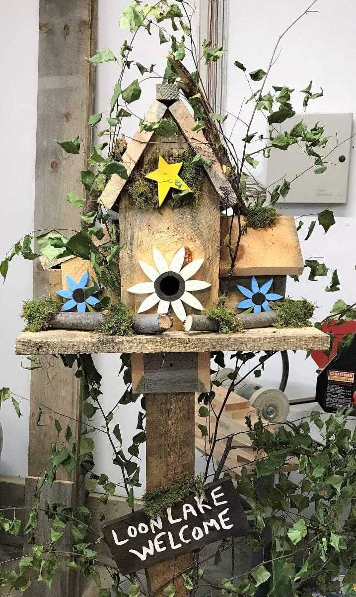 Triple birdhouse with star and flower accents, handcrafted for garden charm.