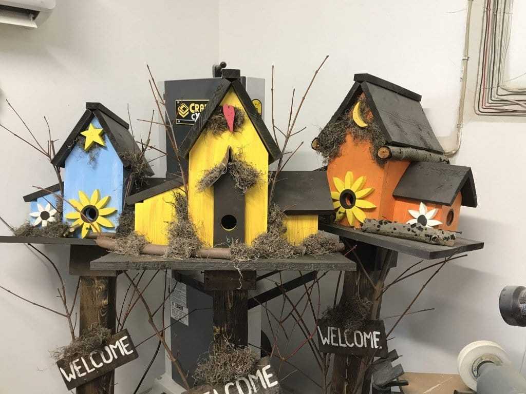 Triple birdhouses with colorful designs and welcome signs, made from pine wood for garden decor.