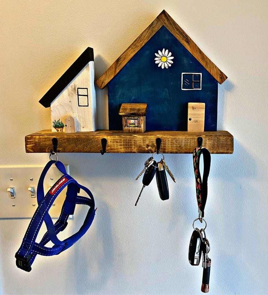 Handmade wooden key chain holder with village house design, wall-mounted organizer.