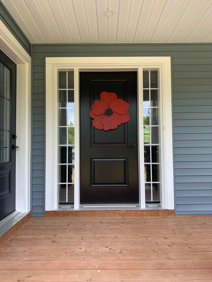 Handcrafted wooden flower door decor on black door, anemone inspired design.