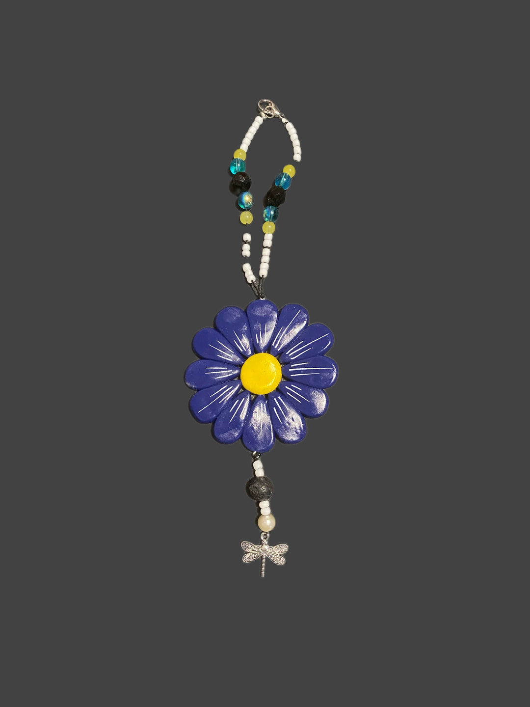 Sofia Daisy car and window charm with hand-sculpted polymer clay petals, glass beads, and black lava bead; supports IWK Foundation.