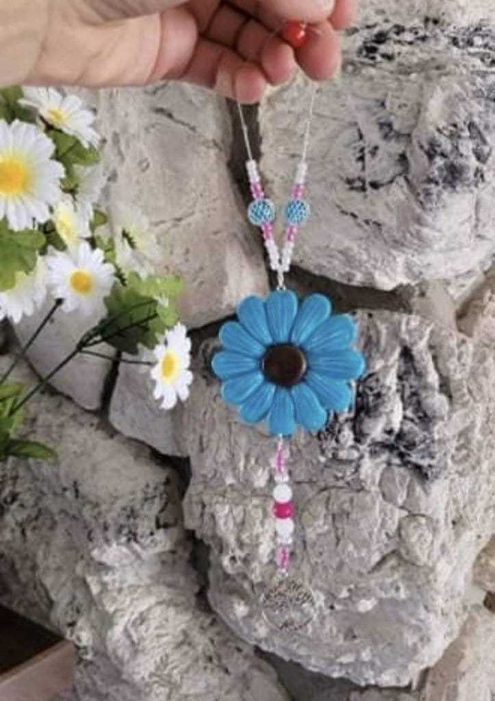 Blue Sofia Daisy car/window charm with black lava bead and glass beads, handmade from polymer clay, supporting IWK Foundation.