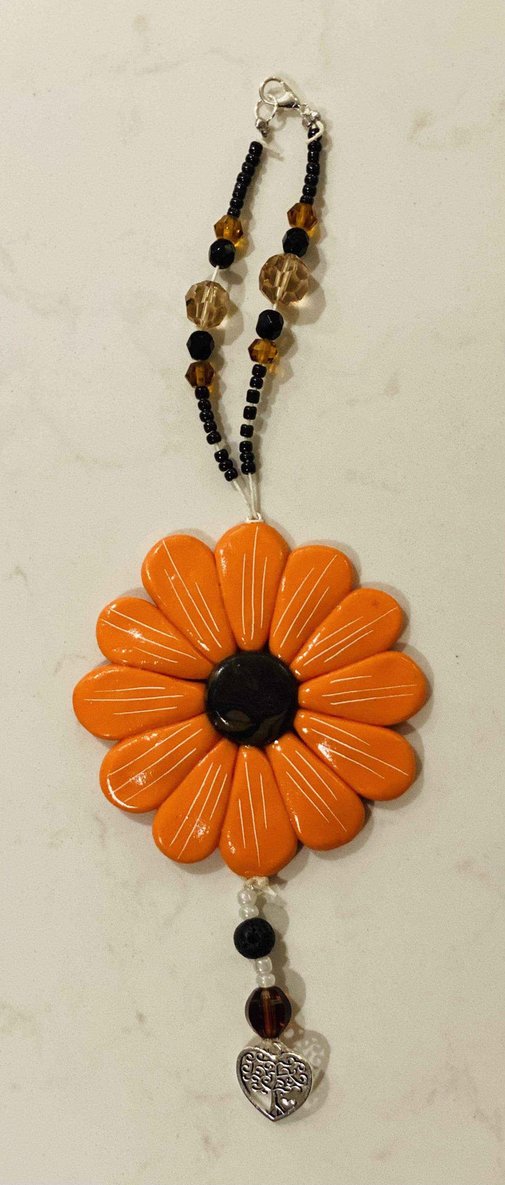 Sofia Daisy Charms for car/window, hand-sculpted polymer clay, black lava bead, glass beads, supports IWK Foundation.