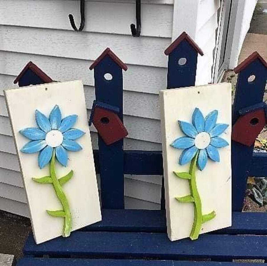 Handcrafted pine wood wall art featuring blue flowers with green stems on white rectangular backgrounds, designed for charming home decor.