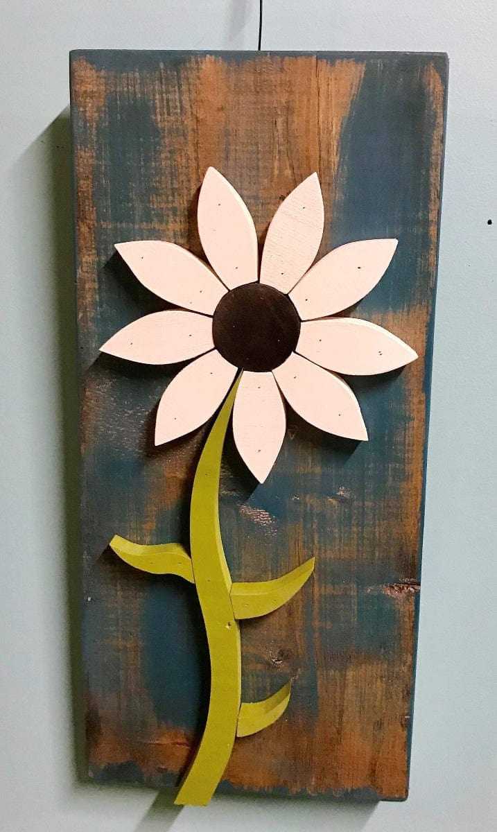 Handcrafted wooden wall art flower with white petals and green stem on rustic brown and blue background