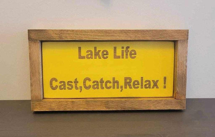 Laser engraved wood sign with "Lake Life Cast, Catch, Relax !" text, ideal for outdoor lovers.