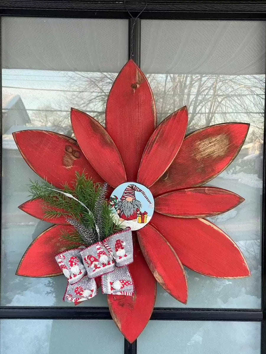 Hand-painted Christmas flower gnome décor with red petals and festive embellishments for outdoor display.