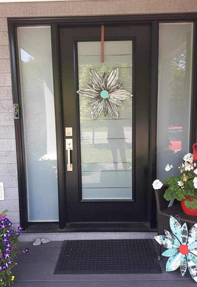 Handcrafted zebra-themed wooden flower hanging on a front door for home decor.