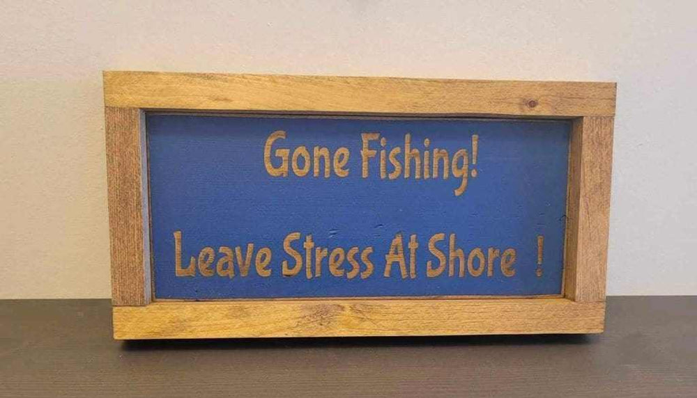 Laser engraved wood sign with "Gone Fishing! Leave Stress At Shore" message, ideal for outdoor enthusiasts and rustic decor.