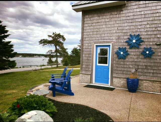 Handcrafted Nova Scotia wooden flower art displayed on house exterior.