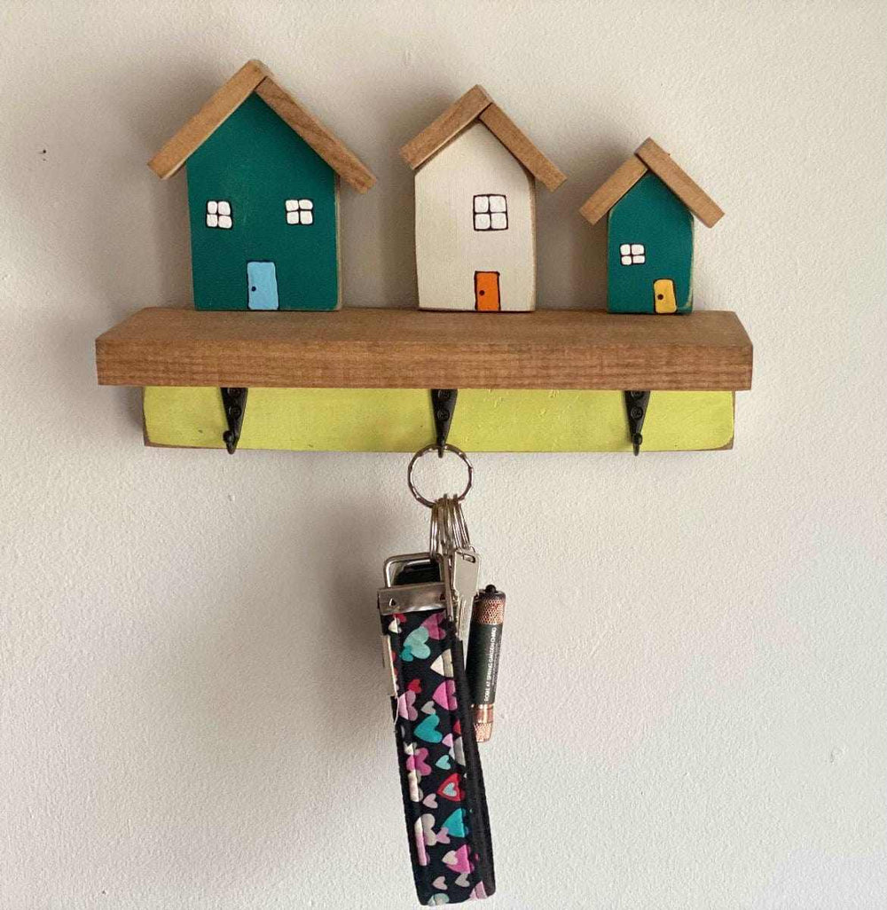 Wall mounted key chain holder with three hooks and house design.