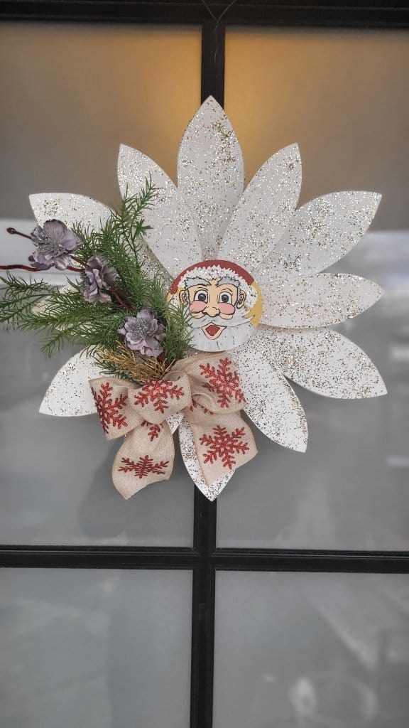 Christmas wooden flower door decoration with hand-painted petals, pine branches, and a festive bow.