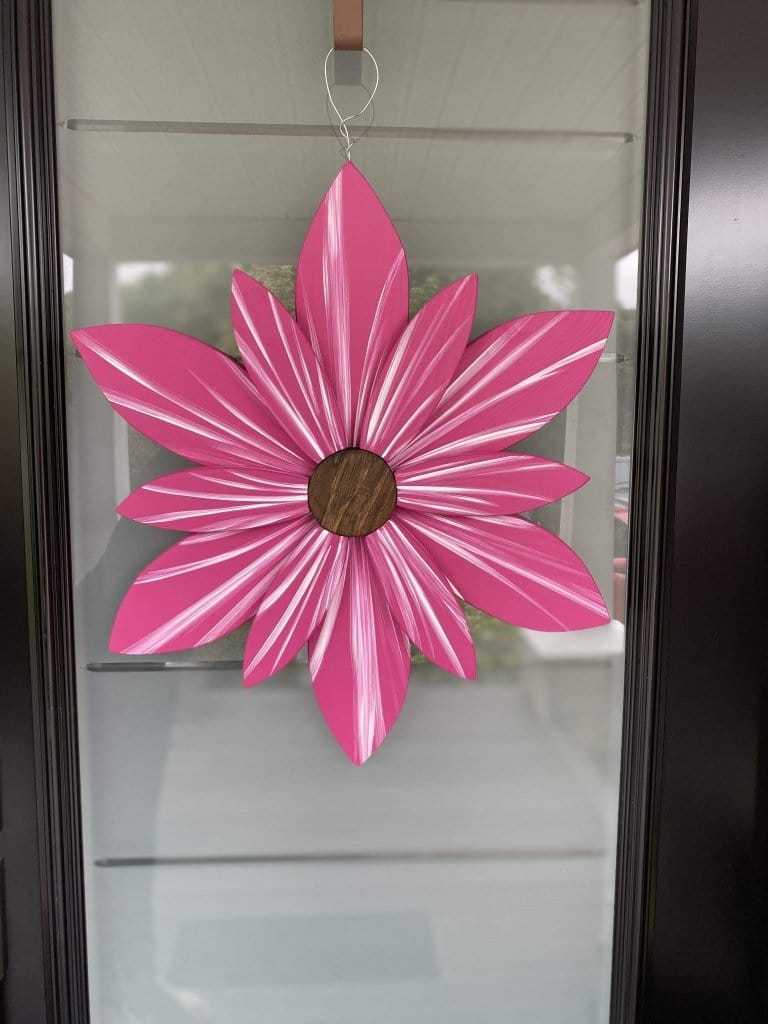 Hand-painted hot pink wooden flower door decor with wire hanger, vibrant petals, and eco-friendly paint.