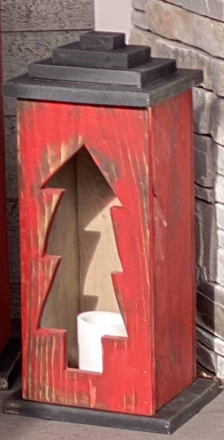 Handcrafted red wooden lantern with tree design.