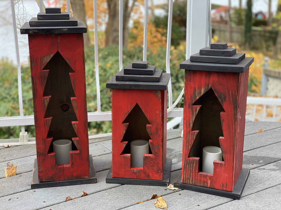 Handcrafted wooden lanterns with intricate tree designs in various sizes, adding warmth and charm to any space.