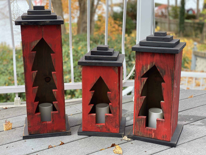 Handcrafted wooden lanterns with intricate tree designs in various sizes, adding warmth and charm to any space.
