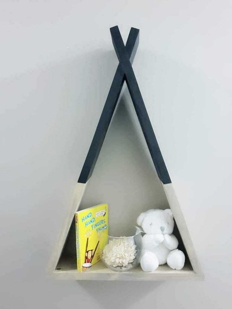 Handcrafted teepee wooden shelf displaying book and teddy bear.