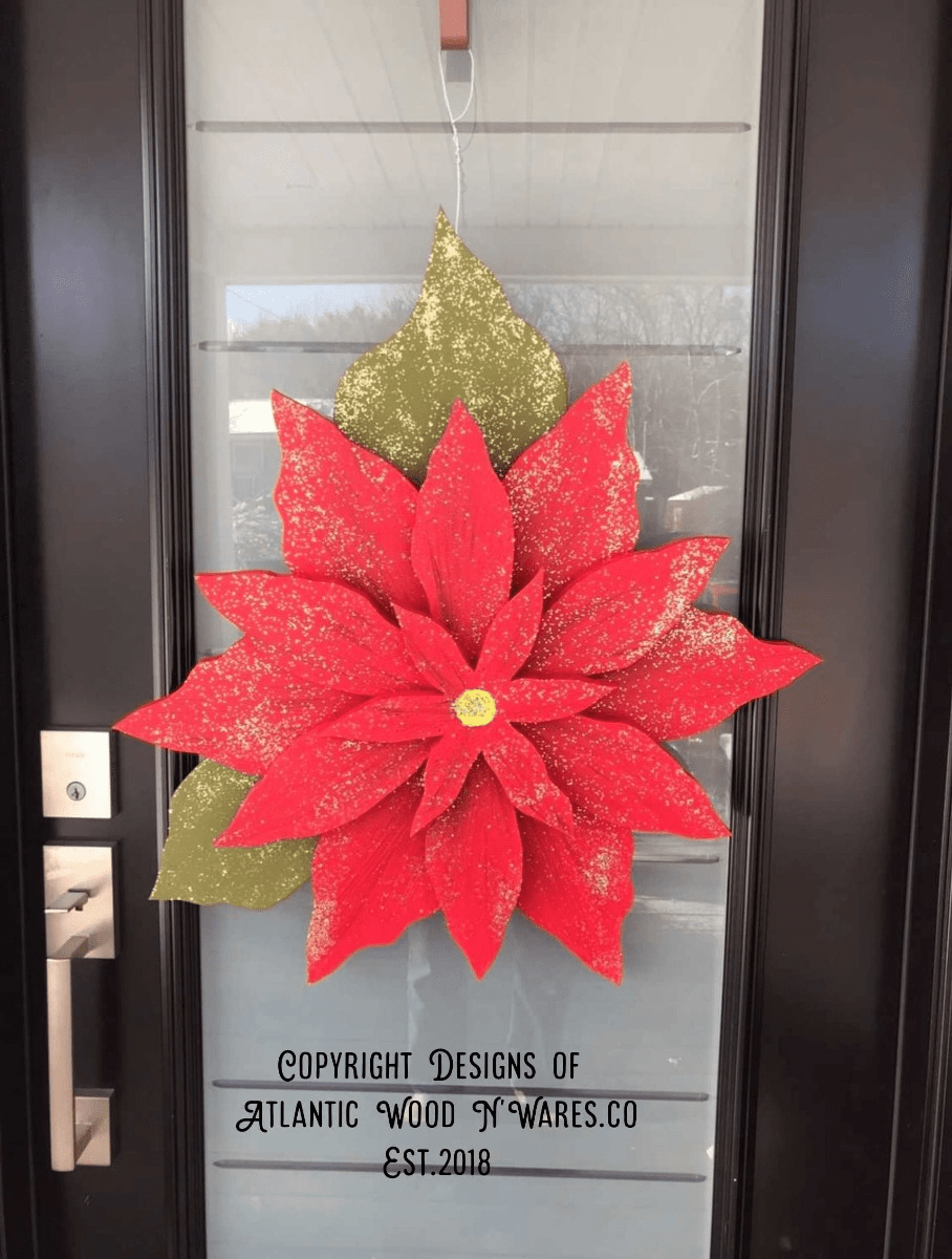 Wooden poinsettia flower decoration on door for holiday season.